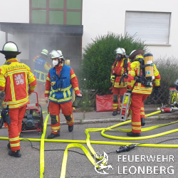 (js) Nach vielen langen Wochen mit Fortbildungen und Trainings im „Corona-Modus“ in Kleingruppen, hat die Feuerwehr Leonberg nun endlich die L&ouml;schzugtrainings wieder aufnehmen k&ouml;nnen. Unter Beachtung aller staatlichen Vorgaben wurde ein Konzept ausgearbeitet und umgesetzt, welches Trainings wieder in der gewohnten St&auml;rke eines L&ouml;schzugs erm&ouml;glicht. Zum Auftakt des Trainingsdienstes wurde der Feuerwehr Leonberg freundlicherweise Zugang zu einem leerstehenden Wohngeb&auml;ude in H&ouml;fingen gew&auml;hrt. 

Wie in einem realen Einsatz auch, erhielten die Fahrzeugf&uuml;hrer der anr&uuml;ckenden Fahrzeuge zun&auml;chst nur wenige Informationen zum Einsatzauftrag. Es wurde angenommen, dass aufmerksame Passanten einen piepsenden Rauchwarnmelder aus einem Wohnhaus geh&ouml;rt, und daraufhin &uuml;ber den Notruf 112 die Feuerwehr alarmiert hatten.

Der zuerst eingetroffene Zugf&uuml;hrer (gr&uuml;ne Weste) konnte die Meldung best&auml;tigen und zudem eine massive Rauchentwicklung im Treppenhaus wahrnehmen. Umgehend forderte er die F&uuml;hrungsgruppe der Abteilung Leonberg nach, welche bei best&auml;tigten Br&auml;nden zur Unterst&uuml;tzung der Einsatzleitung t&auml;tig wird. Ein gespielter Bewohner des Hauses wurde zu m&ouml;glicherweise vermissten Personen und besonderen Gefahren im Geb&auml;ude befragt.

Da mindestens eine Person im Geb&auml;ude vermisst wurde, kam unverz&uuml;glich ein mit Atemschutzger&auml;ten ausger&uuml;steter Trupp zur Menschenrettung zum Einsatz. Unter sogenannter Nullsicht durchsuchte dieser im weiteren Verlauf systematisch alle Wohnungen. Nach dem Auffinden der Person wurde diese zu einem Fenster gebracht und dort von der Besatzung der Drehleiter in den Rettungskorb &uuml;bernommen. Ein weiterer Trupp, welcher sich parallel zur Brandbek&auml;mpfung durch den dichten Rauch in das Untergeschoss vorarbeitete, konnte z&uuml;gig die Brandquelle ausfindig machen und L&ouml;schma&szlig;nahmen einleiten. 

W&auml;hrend die Mannschaft der beiden eingesetzten L&ouml;schfahrzeuge und der Drehleiter weiterhin mit der Menschenrettung und Brandbek&auml;mpfung besch&auml;ftigt war, wurde am Einsatzleitwagen die Lagekarte gef&uuml;hrt. In regelm&auml;&szlig;igen Abst&auml;nden kamen alle im Einsatz befindlichen F&uuml;hrungskr&auml;fte zu kurzen Besprechungen zusammen, um wichtige Informationen auszutauschen und gezielt den Einsatz leiten zu k&ouml;nnen. 

Realit&auml;tsnah mussten die Trupps im Innenangriff mehrere T&uuml;ren mit Spezialwerkzeug &ouml;ffnen, blockierte Zug&auml;nge zu einzelnen R&auml;umen &uuml;berwinden und auch besondere Gefahren wie Gasleitungen erkennen. Dichter Rauch, piepsende Rauchwarnmelder, eine starke Hitzeentwicklung im Untergeschoss und verwinkelte Wohnungen mit darin zu rettenden Personen steigerte die Belastung f&uuml;r die Trupps ungemein. Nach rund einer Stunde war das Training beendet und die eingesetzten Trupps waren sichtlich ersch&ouml;pft. 

F&uuml;r die neuen Feuerwehrleute war es das erste Mal, das in der Theorie erlernte Wissen bei einer solchen Einsatzlage anzuwenden. Stetig m&uuml;ssen sich die Einsatzkr&auml;fte fortbilden und &uuml;ben, da kein Einsatz einem anderen gleicht. 

Nach den Aufr&auml;umarbeiten wurde in der Feuerwache in Leonberg eine Nachbesprechung durchgef&uuml;hrt. Dies ist sowohl nach realen Eins&auml;tzen als auch bei Trainings sehr wichtig, um gemeinsam mit der Mannschaft das taktische Vorgehen zu analysieren. Nach langer Zeit mit ausschlie&szlig;lichen Online-Unterrichten, waren die Leonberger Feuerwehrleute sichtlich froh, ihr K&ouml;nnen in einem praktischen und zugleich lehrreichen Training unter Beweis zu stellen. 

Wir freuen uns auf weitere derartige Trainings in kommender Zeit. 
Besonderer Dank gilt den Hauseigent&uuml;mern f&uuml;r die Bereitstellung des &Uuml;bungsgeb&auml;udes.
